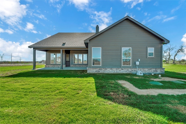 rear view of house with a lawn and a patio area