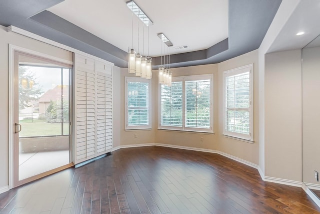 unfurnished dining area with dark hardwood / wood-style flooring and a chandelier