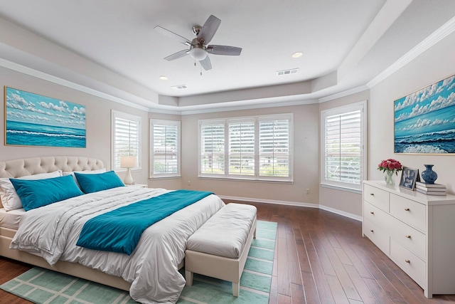 bedroom with ornamental molding, a tray ceiling, ceiling fan, and dark wood-type flooring