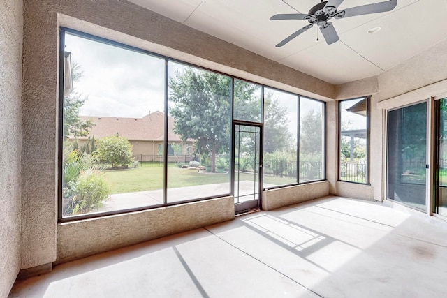 unfurnished sunroom featuring ceiling fan