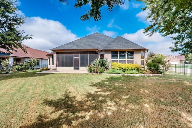 rear view of property featuring a sunroom and a yard