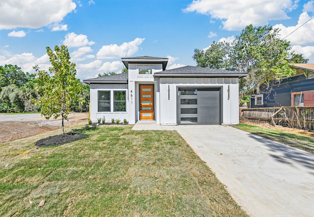 prairie-style house featuring a garage and a front lawn