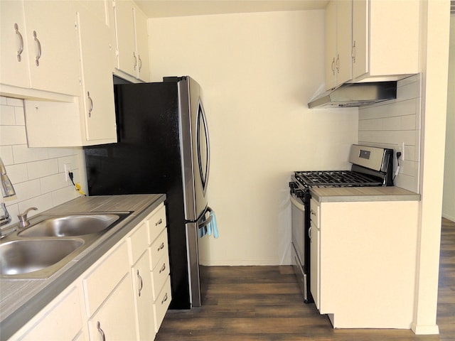 kitchen with dark wood-type flooring, sink, white cabinetry, decorative backsplash, and stainless steel appliances