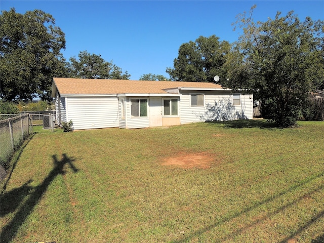 rear view of property featuring a yard and central AC unit