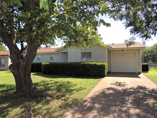 ranch-style home featuring central AC unit, a front yard, and a garage