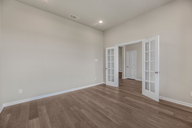 spare room featuring french doors and hardwood / wood-style flooring