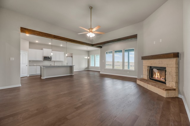 unfurnished living room with ceiling fan, a fireplace, and dark hardwood / wood-style floors