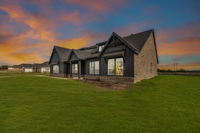 property exterior at dusk with a yard