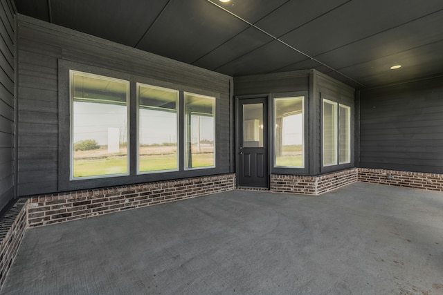 interior space featuring wood walls and brick wall