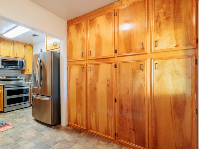 kitchen featuring appliances with stainless steel finishes and tasteful backsplash