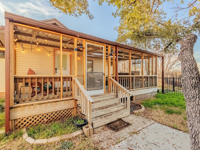 back of house with ceiling fan, a sunroom, and a patio