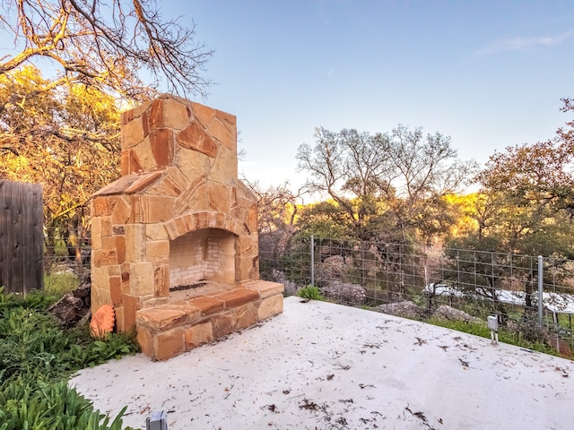 yard at dusk featuring an outdoor stone fireplace