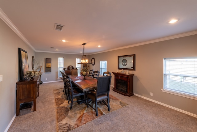 dining area featuring light carpet, a wealth of natural light, an inviting chandelier, and ornamental molding