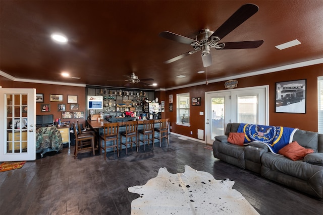 living room with ornamental molding, dark hardwood / wood-style flooring, ceiling fan, and indoor bar