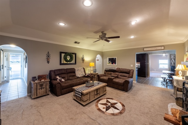 carpeted living room with ornamental molding and ceiling fan