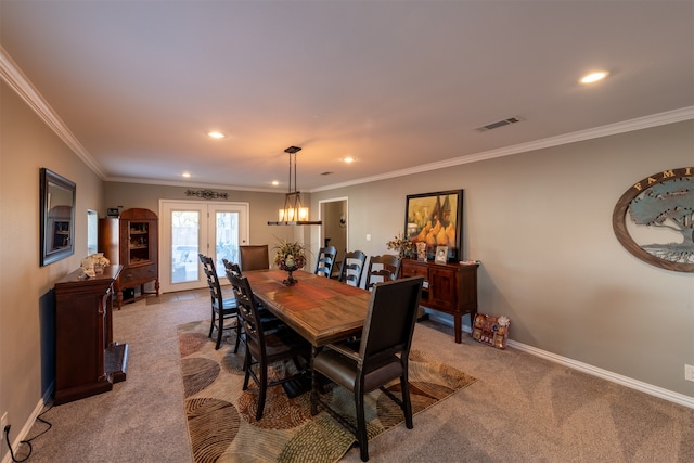 dining space with crown molding, light colored carpet, and french doors