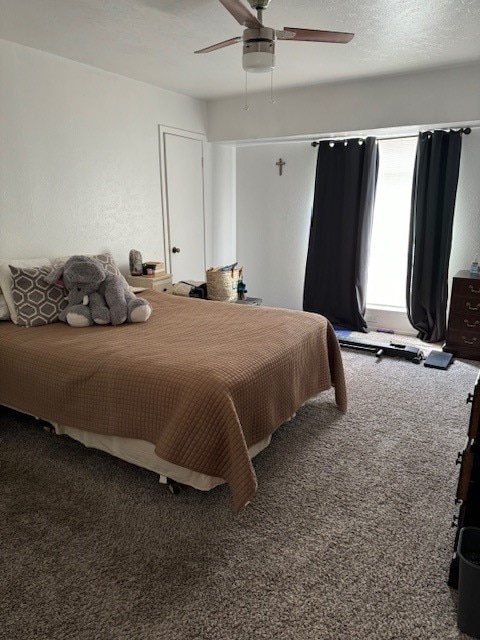 bedroom with ceiling fan, a textured ceiling, and carpet flooring