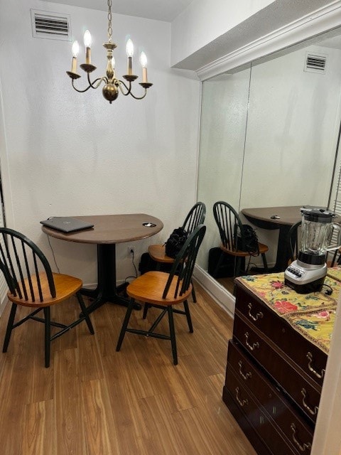 dining room with light hardwood / wood-style flooring and an inviting chandelier