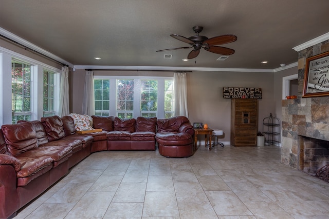 living room featuring ornamental molding, ceiling fan, and a stone fireplace