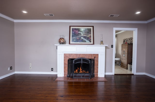 unfurnished living room featuring ornamental molding, a tiled fireplace, and dark wood-type flooring