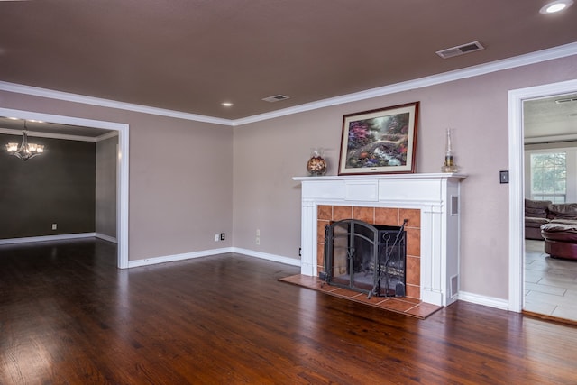 unfurnished living room with ornamental molding, a chandelier, a tile fireplace, and dark hardwood / wood-style flooring