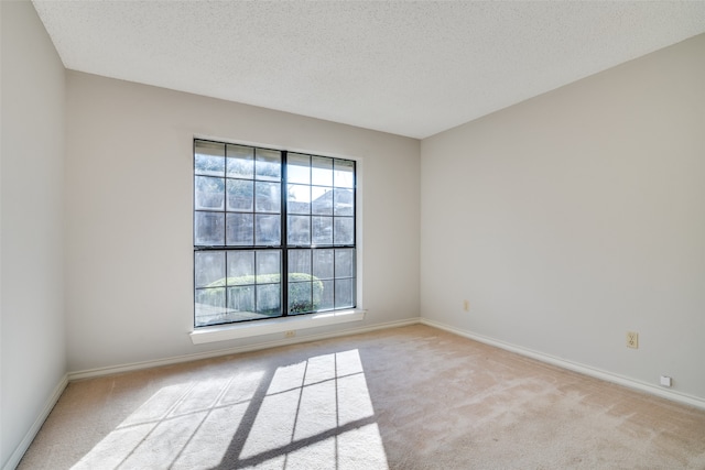 carpeted empty room featuring a textured ceiling