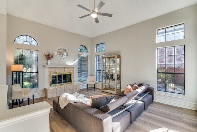 living room featuring a healthy amount of sunlight, light hardwood / wood-style floors, and a towering ceiling