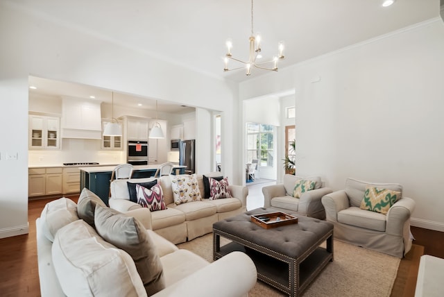 living room with a chandelier, hardwood / wood-style floors, and crown molding