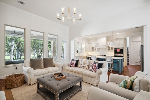 living room with a notable chandelier, light hardwood / wood-style floors, and crown molding