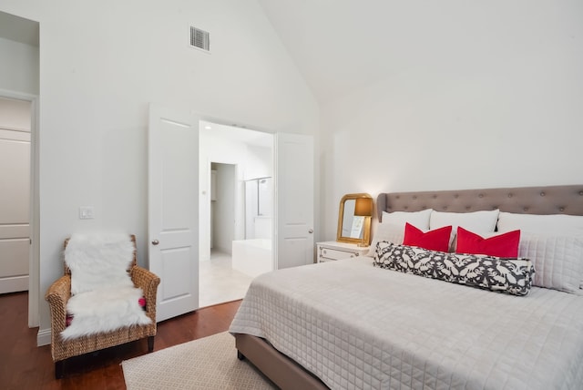 bedroom featuring dark wood-type flooring and high vaulted ceiling