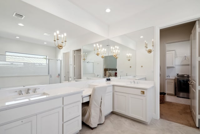 bathroom featuring washer / clothes dryer, vanity, and a shower with door