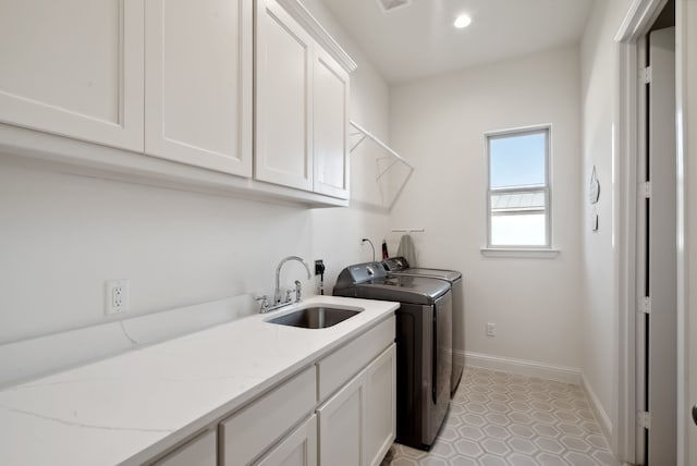 laundry room featuring cabinets, sink, washing machine and dryer, and light tile patterned flooring