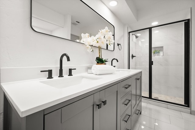 bathroom with walk in shower, vanity, and tile patterned floors