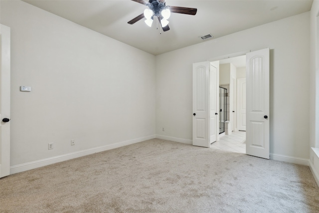 carpeted spare room featuring ceiling fan