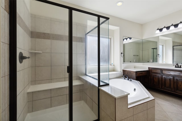 bathroom with tile patterned flooring, vanity, and separate shower and tub