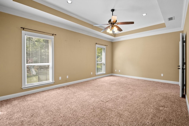 carpeted empty room with crown molding, a tray ceiling, and ceiling fan