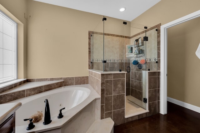 bathroom with a healthy amount of sunlight, independent shower and bath, and vanity