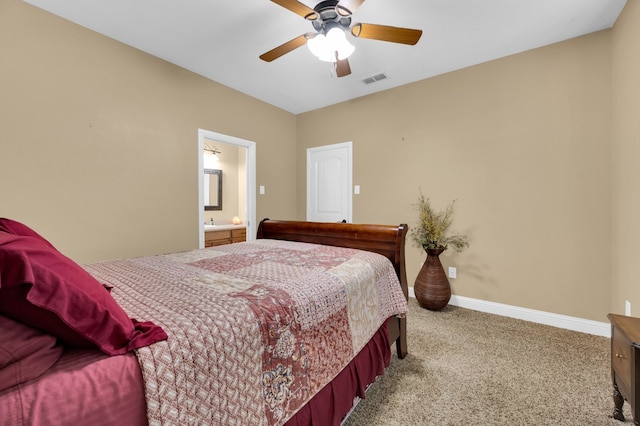 bedroom with ceiling fan, light carpet, and ensuite bathroom