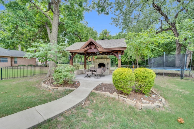 view of community featuring a trampoline, a gazebo, a lawn, and a patio