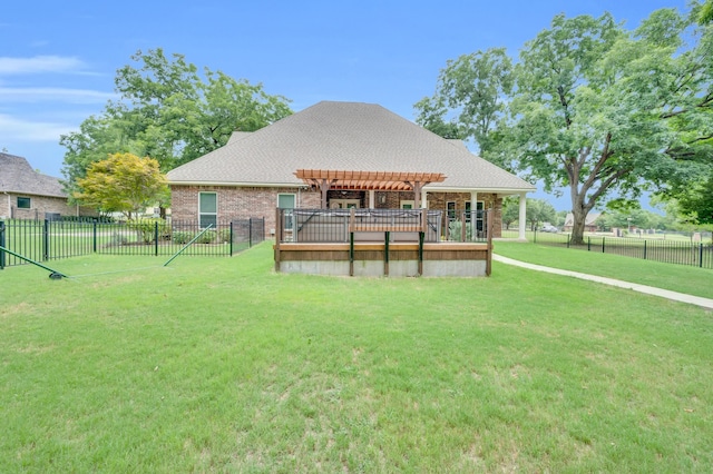 rear view of house featuring a lawn and a deck