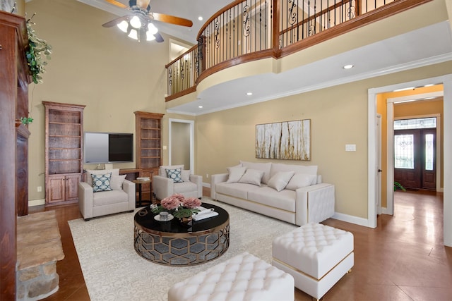 living room featuring a towering ceiling, ceiling fan, and crown molding