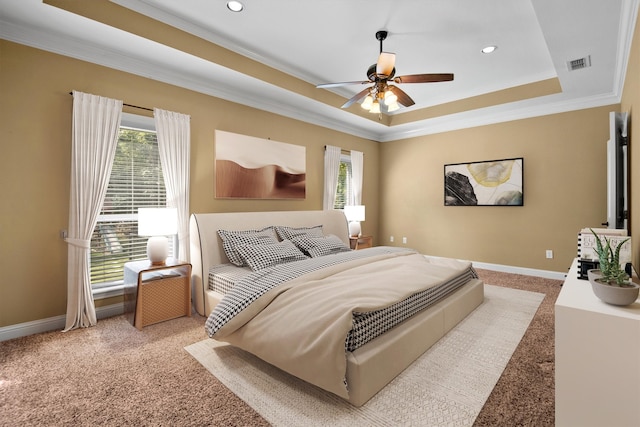 carpeted bedroom with ornamental molding, a tray ceiling, and ceiling fan