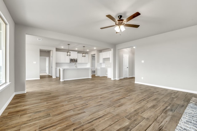 unfurnished living room featuring ceiling fan