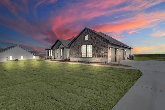 property exterior at dusk with a garage, cooling unit, and a lawn