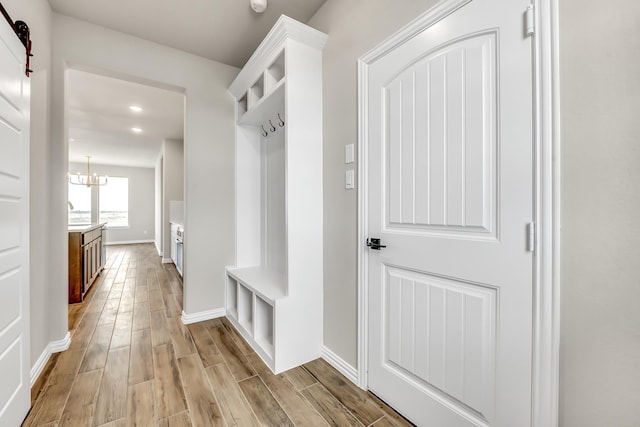 mudroom with a notable chandelier and a barn door