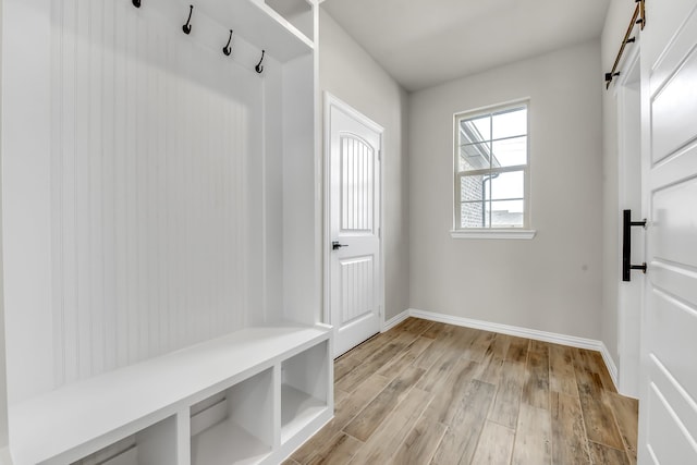 mudroom featuring a barn door and light hardwood / wood-style flooring