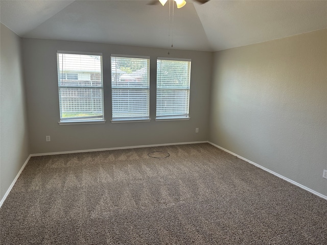 spare room featuring carpet, vaulted ceiling, and ceiling fan