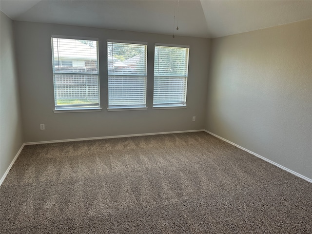 carpeted spare room with vaulted ceiling