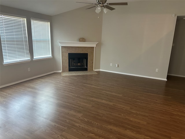 unfurnished living room with ceiling fan, a tile fireplace, and dark hardwood / wood-style flooring