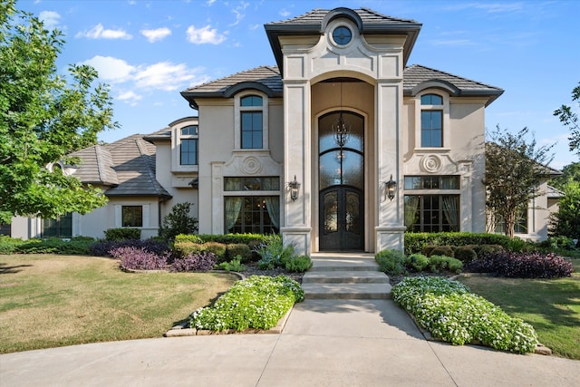 view of front of home with a front lawn and french doors